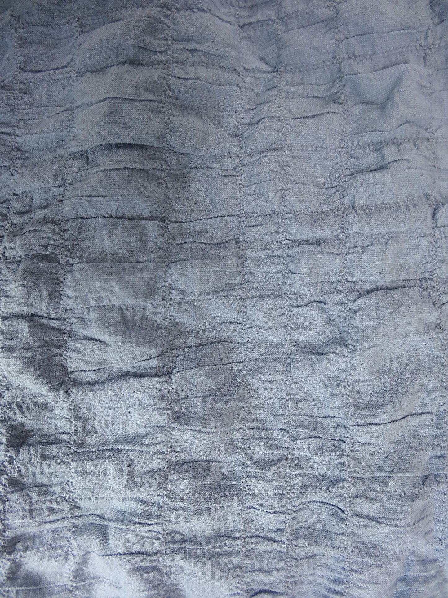 Close-up of textured blue fabric with ruched pattern