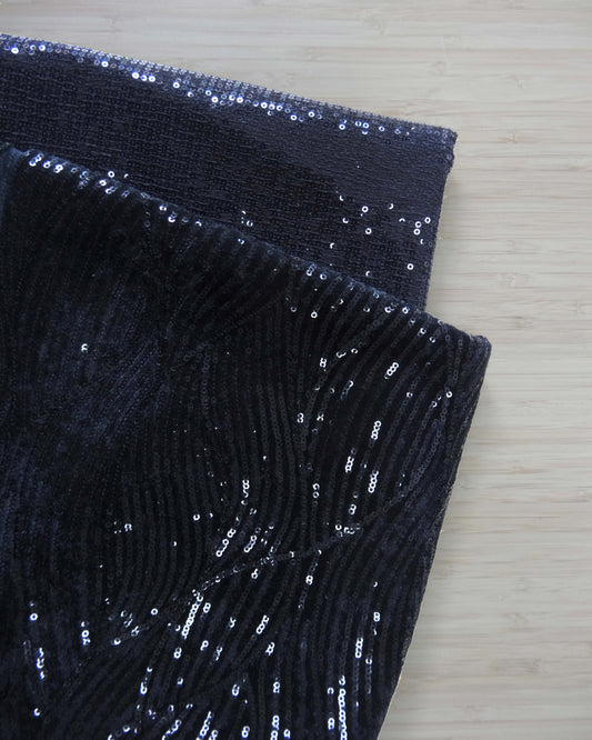Two different styles of black sequin fabrics folded