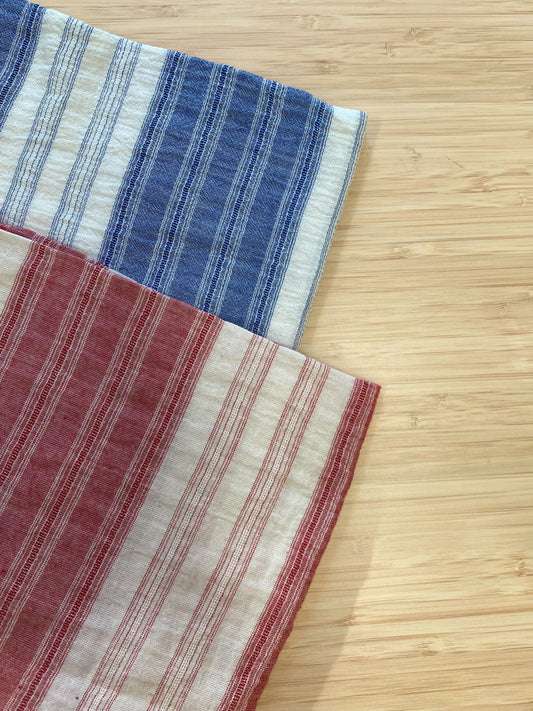 Two colours of striped cotton spandex fabric. one blue and white, one red and white.
