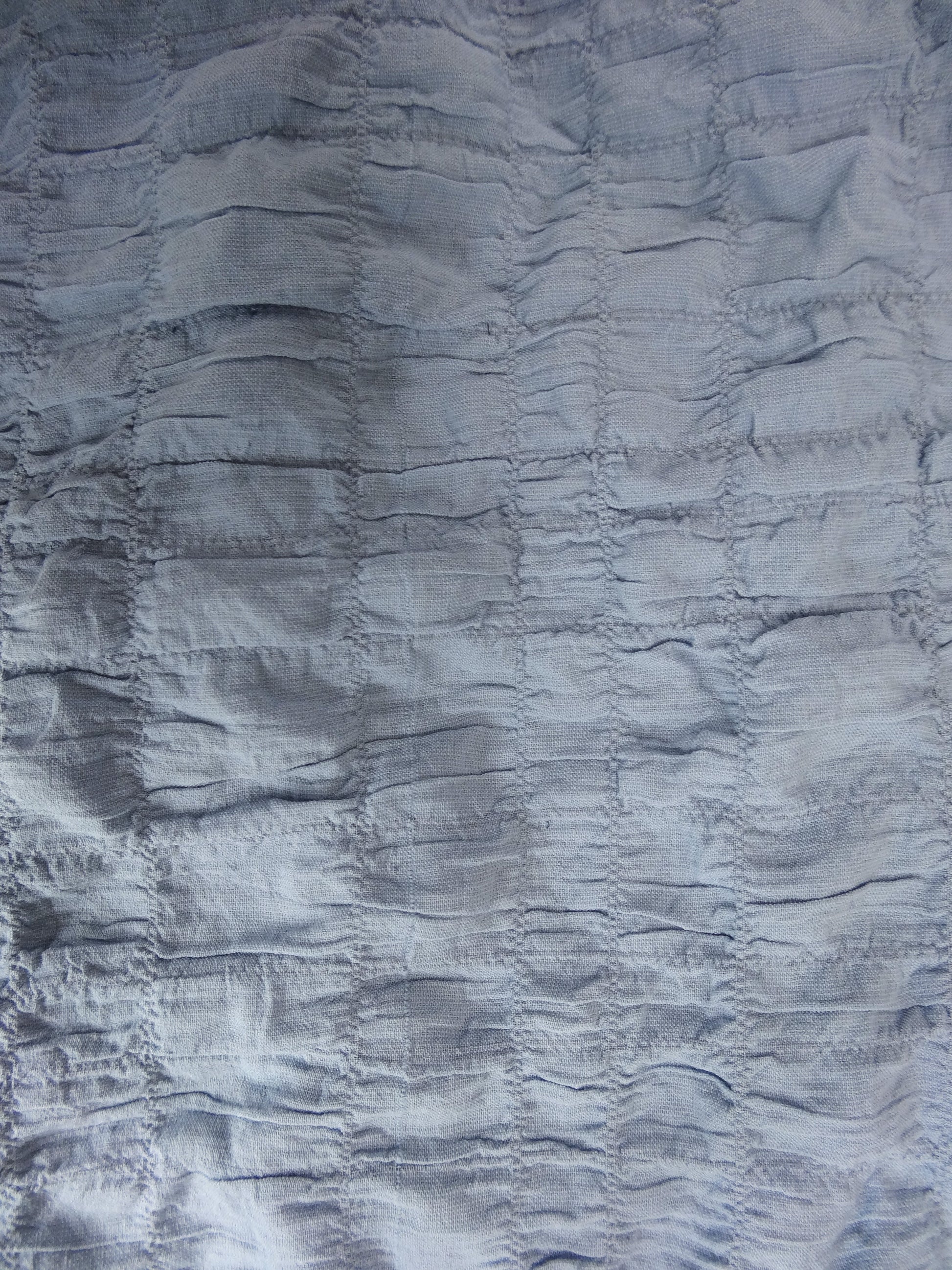 Close-up of textured blue fabric with ruched pattern