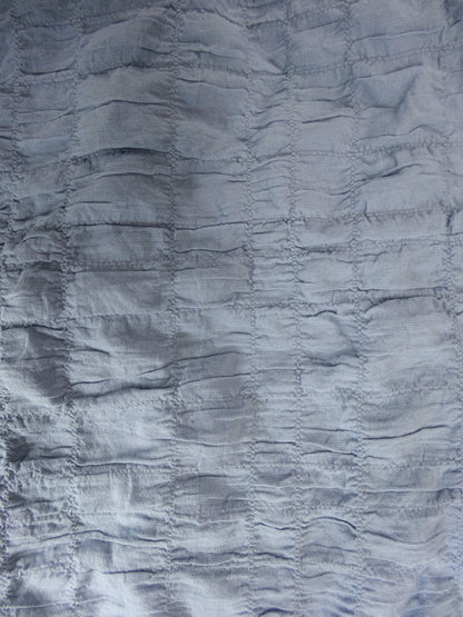 Close-up of textured blue fabric with ruched pattern