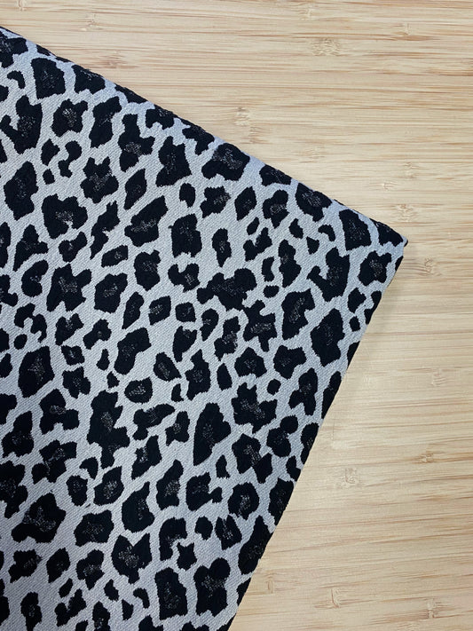 Leopard Print Flocked Cotton fabric folded and photographed from above on a wooden table.
