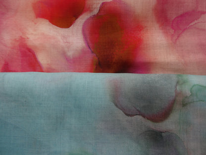 Photo of abstract watercolour abstract digital print on lightweight ramie fabric remnants stacked in blues and pinks. photographed from above.