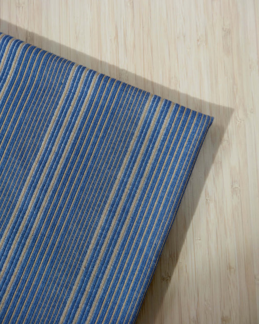 Blue and beige striped yarn dye ponte fabric photographed from above on wooden table
