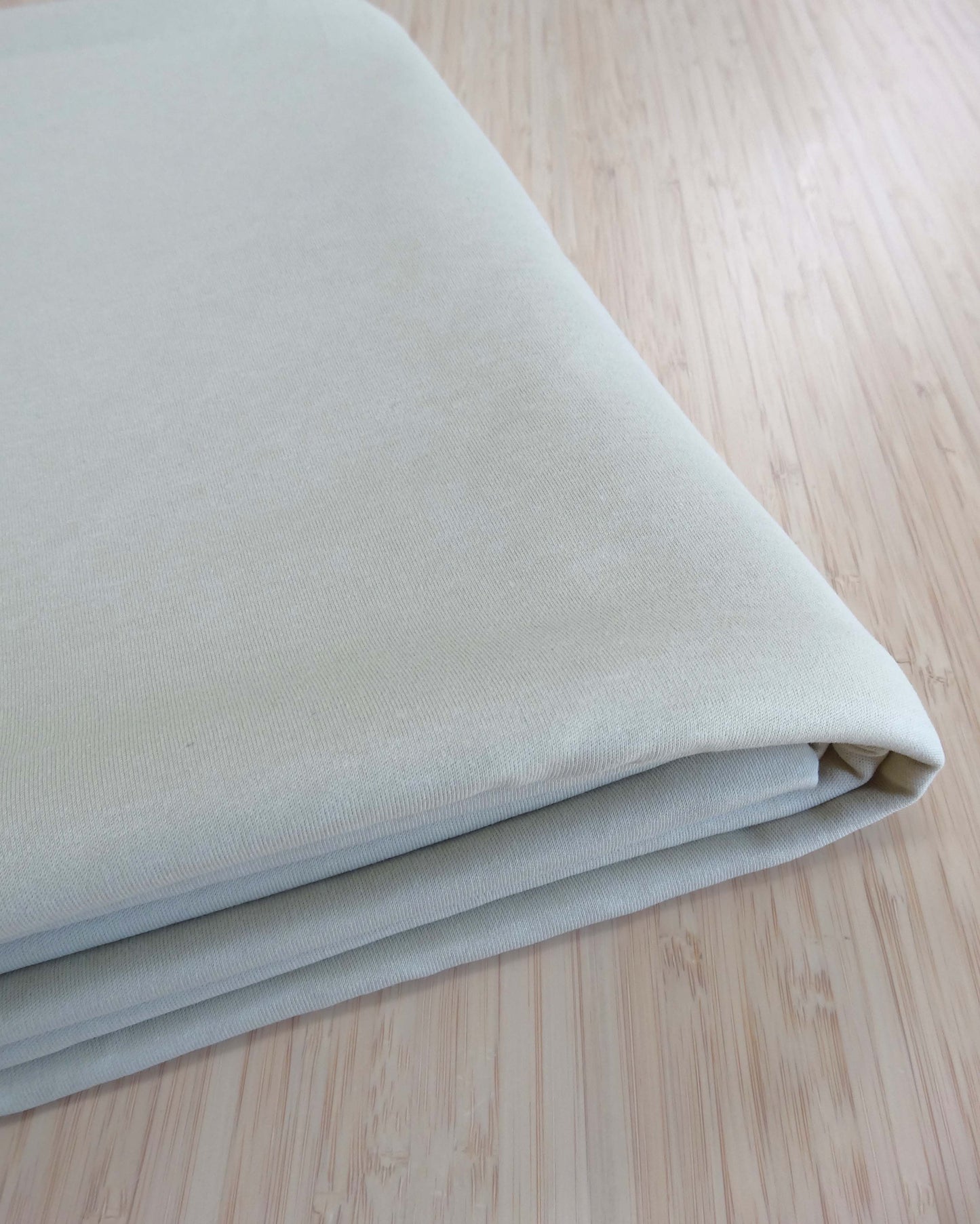 Folded light beige fabric on a wooden surface