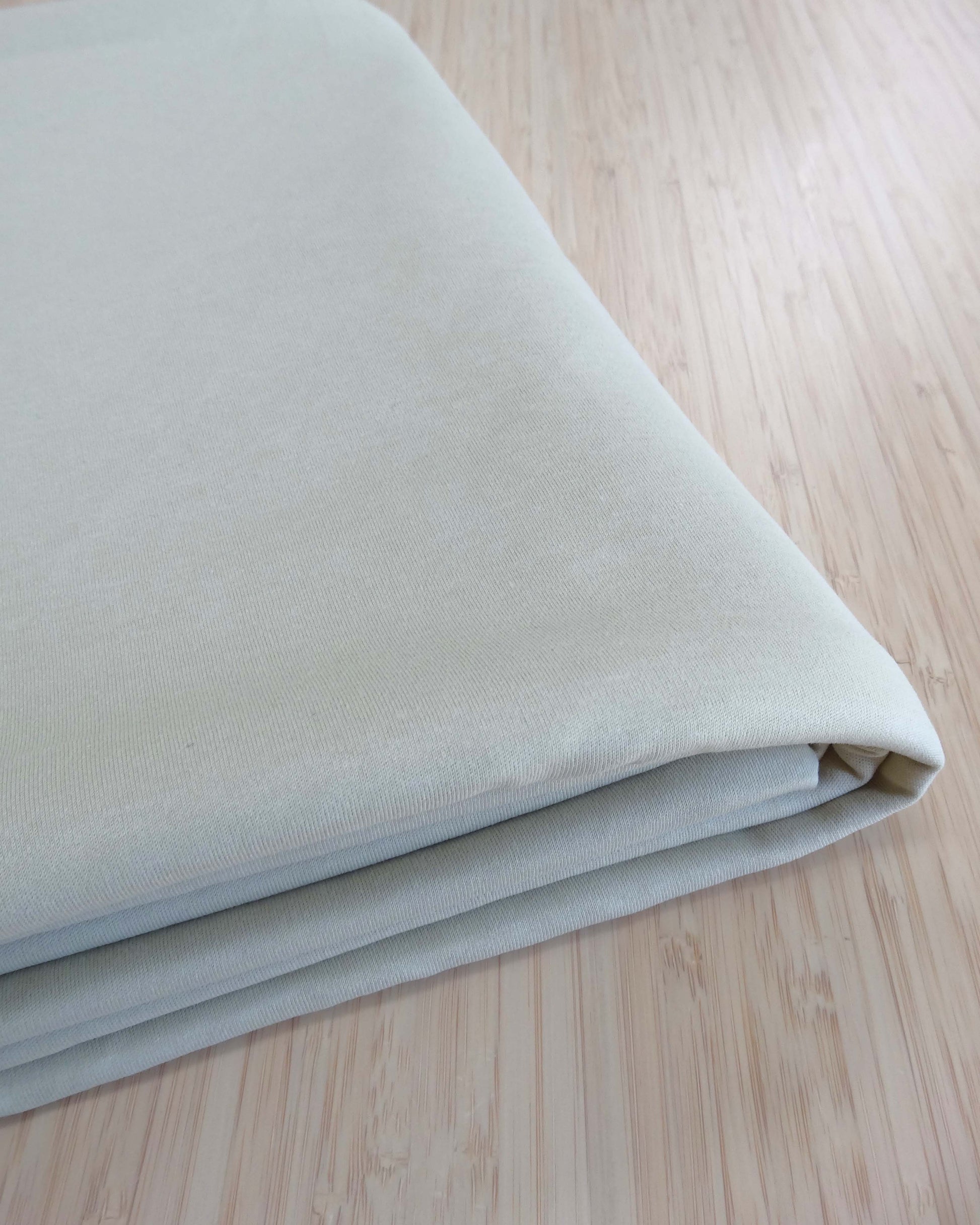 Folded light beige fabric on a wooden surface