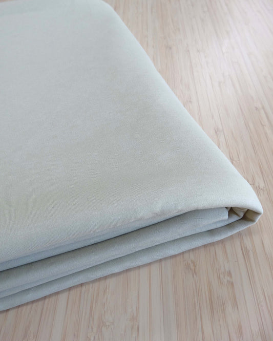 Folded light beige fabric on a wooden surface